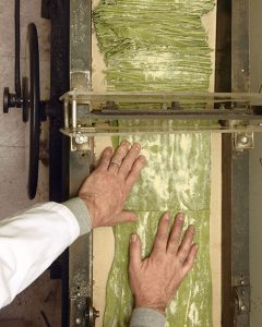 Andrew Raffetto runs sheets of spinach pasta through the store’s 90-year-old pasta cutter. Photo by Leo Sorel