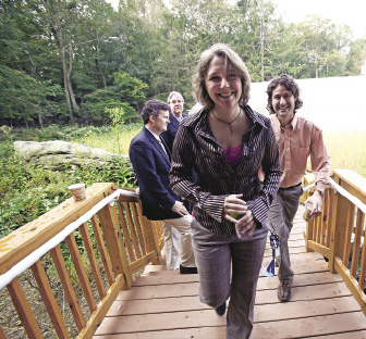 Doctoral candidates Dawn Konkoly (center) and Jason Aloisio are the first students to live in the log cabin-style residence. Photo by Bruce Gilbert