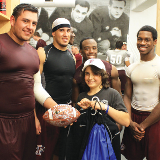 Jonah Shainberg receives a football signed by members of Fordham’s football team. Evidently Shainberg brought the Rams good luck; they won against Temple 30-29 on Sept. 14. Photo by Joe DiBari