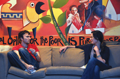 Dan Drolet and Camden Team Leader Angela Pokorny (FCRH ’11) reflect on their day of service in the Romero Center’s lounge. Photo by Janet Sassi