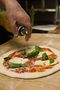Joseph Migliucci, chef and owner of Mario's Restaurant, prepares pizza the way his father taught him.