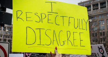 A sign at a recent protest march that says I respectfully disagree