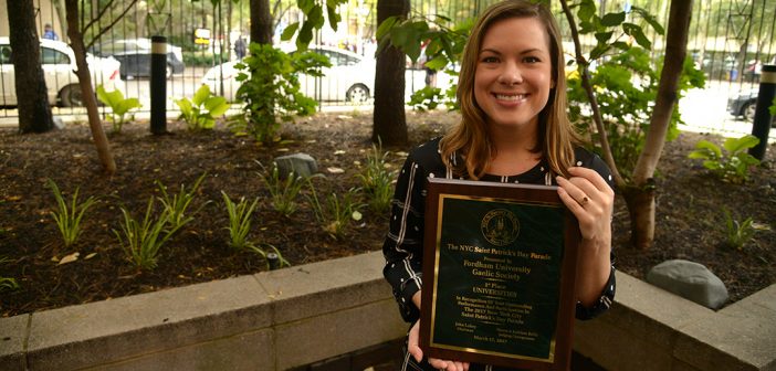 Shannon Hirrel Quinn holds the plaque honoring Fordham's participation in the St. Patrick's Day Parade