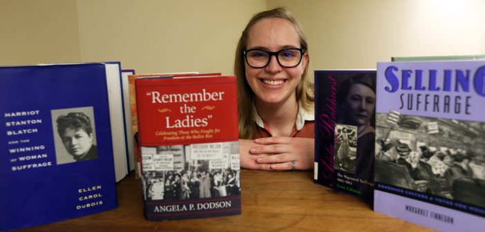 Bookshelf of Suffragette books with grad student