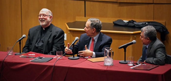 Father Patrick Ryan talks with Rabbi Daniel Polish and Professor Zaki Saritoprak at a long table with microphones at the 2018 McGinley Lecture on the Rose Hill campus