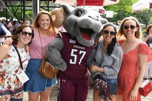 Young alumni with Fordham's mascot, Ramses