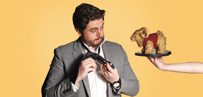 Saturday Night Live writer (and Fordham graduate) Streeter Seidell puts on a necktie and looks at a stuffed toy Fordham Ram on a silver platter