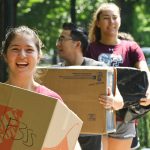 Student volunteers carry boxes on the Rose Hill campus