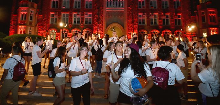 Student volunteers fan out from the steps of Keating Terrace with lit candles.