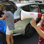 A student volunteer welcomes first year students to the Rose Hill campus through a bullhorn.
