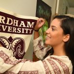 Olivia Jones, a first year student at Fordham College at Rose Hill, hangs a Fordham banner in her room at Alumni Court South