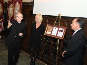 Father McShane and Kim Bepler pay tribute to Stephen Bepler, a "true son of Fordham," while Robert Daleo, the chair of Fordham's Board of Trustees looks on.