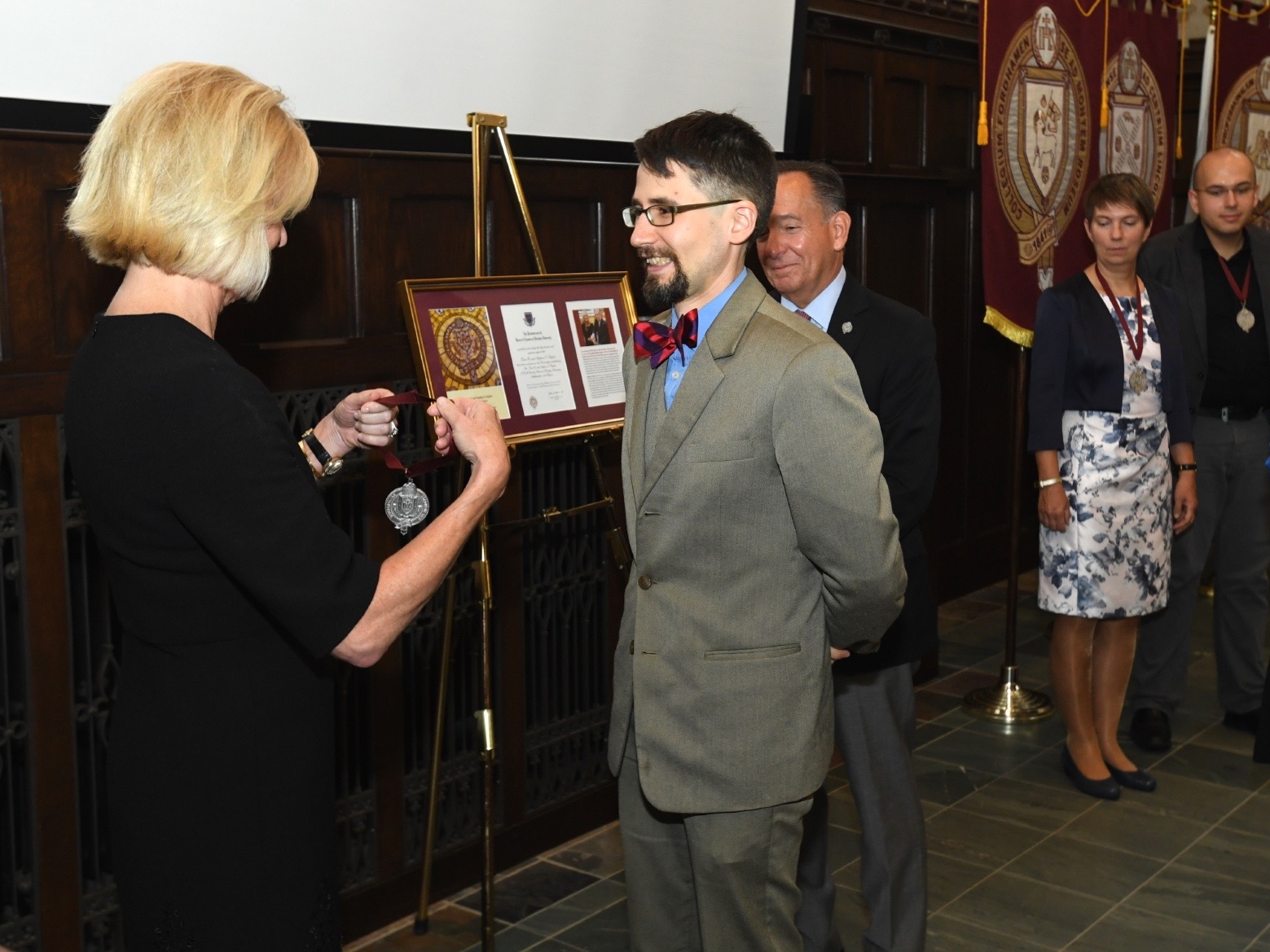 Kim Bepler presents Joshua Schrier, the Kim B. and Stephen E. Bepler Chair in Chemistry, with his medal.