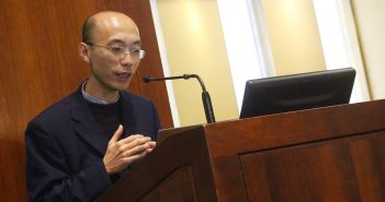 Weiping Zheng, an epistemologist from Xiamen University, speaks about the rules behind making assertions, behind a podium at the front of the room.