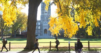 Keating Hall as seen through trees with leaves turning yellow