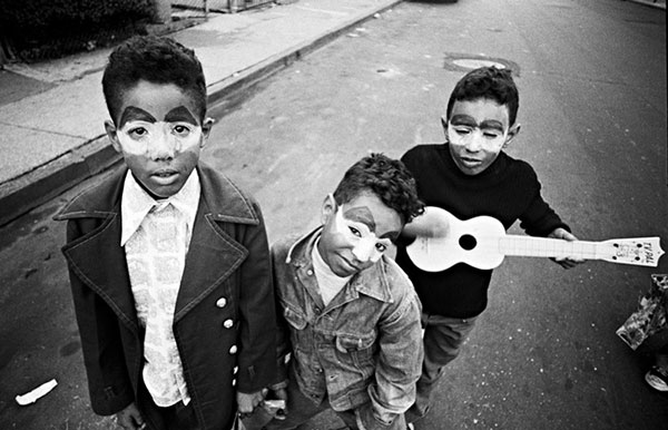 Three boys wearing tear makeup for Halloween. One boy holds a toy guitar.