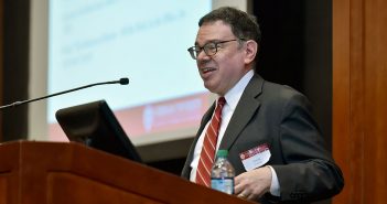 Fordham professor Mark Conrad speaking at podium during a November 2018 lecture
