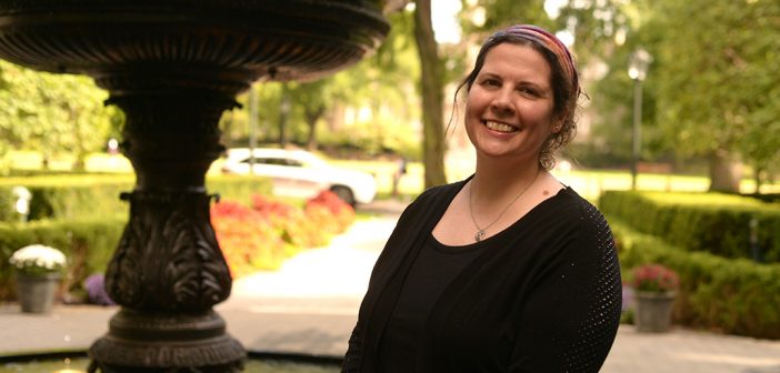 Keri Walsh, Ph.D., associate professor of English, stands next to the fountain on the Rose Hill campus