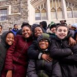 Young Catholic school students in winter coats posing on the Rose Hill campus