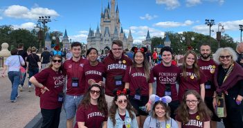 Gabelli School of Business students pose for a group picture in front of Cinderella's castle in Disney World