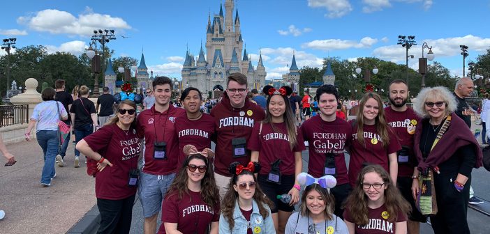 Gabelli School of Business students pose for a group picture in front of Cinderella's castle in Disney World