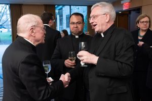 Priests talk to each other at a reception.