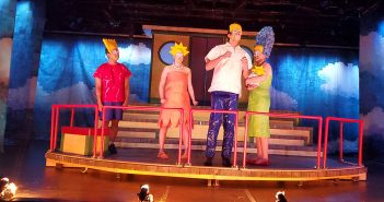 The cast of Mr. Burns dressed as Bart, Lisa, Homer and Marge, on stage in Pope Auditorium.