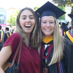 A woman graduate poses for a picture with another woman