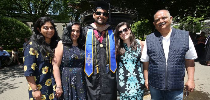 A family poses for a picture with a graduate