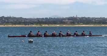 The men's crew team rowing on the water.