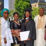 A family poses with a graduate wearing a black academic robe