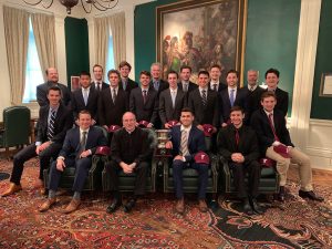 The hockey team seated with Father McShane