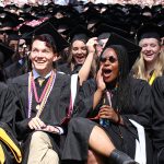 Graduates seated, wearing black academic robes