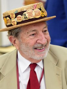 A man wearing a straw hat covered with badges
