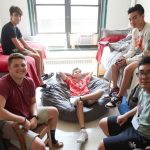Five young students pose for a picture in a dorm.
