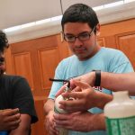 Two high school students work on scientific devices.