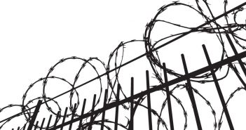 Line drawing of fence topped by razor wire