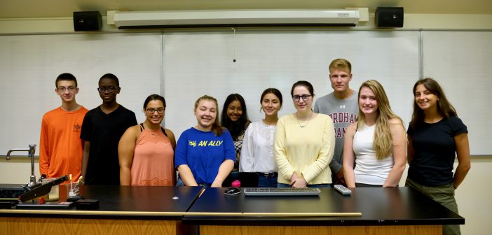 Ten students pose for a group picture in a lab.