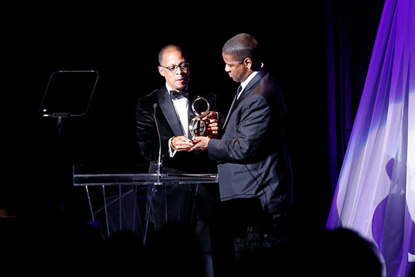 Denzel Washington receives the award from Anthony Carter.