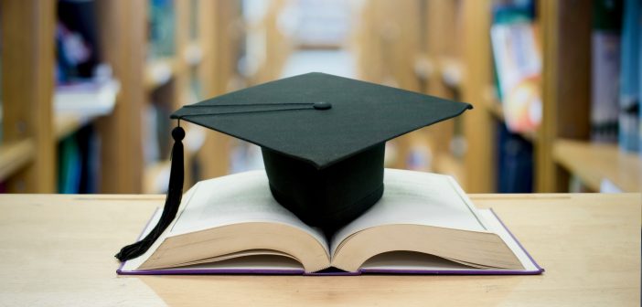 A black graduation cap on an open book