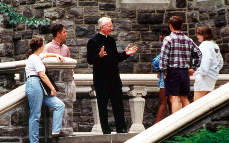 Father O'Hare talking with students at Rose Hill