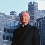 Father O'Hare in front of O'Hare Hall at Rose Hill