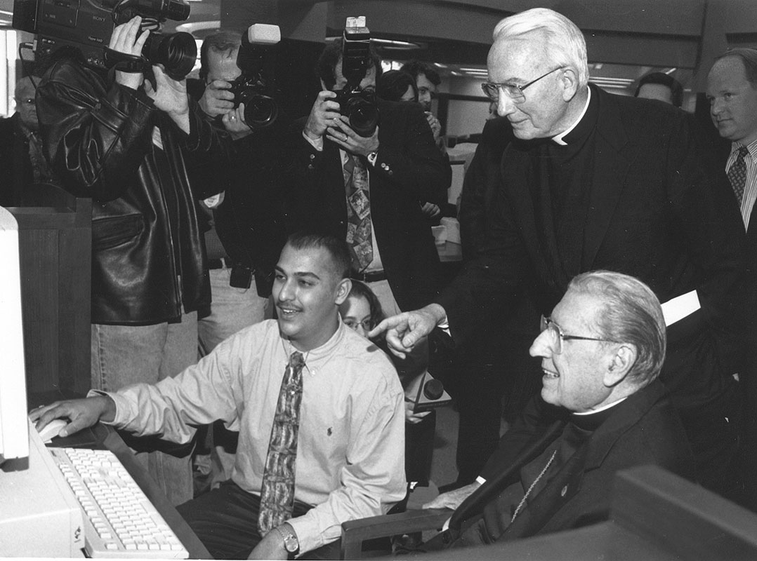 In 1997, John Cardinal O’Connor (right) blessed the William D. Walsh Family Library, then joined Father O’Hare and Mohammad Kahn (FCO ’00) for a tour of the Vatican’s website. Photo by Ken Levinson.