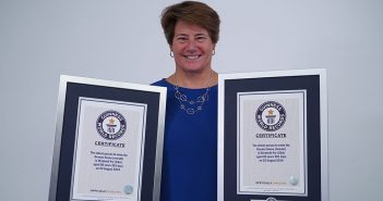 A woman holds two awards