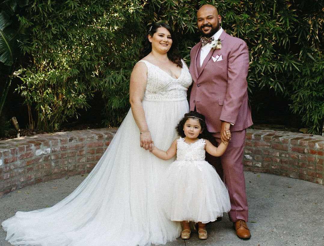 Fordham graduate Camille Sanchez and Julian Martinez on their wedding day with their daughter, Penelope