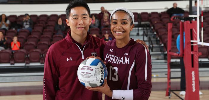 Volleyball coach poses with player