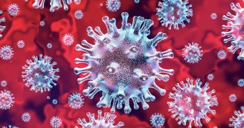 A microscopic coronavirus against a red background
