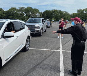 Father McShane greets family in car at Rose Hill