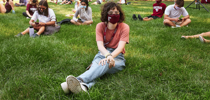 woman sitting in grass with mask