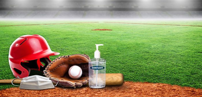 A baseball helmet, glove, and hand sanitizer on a field